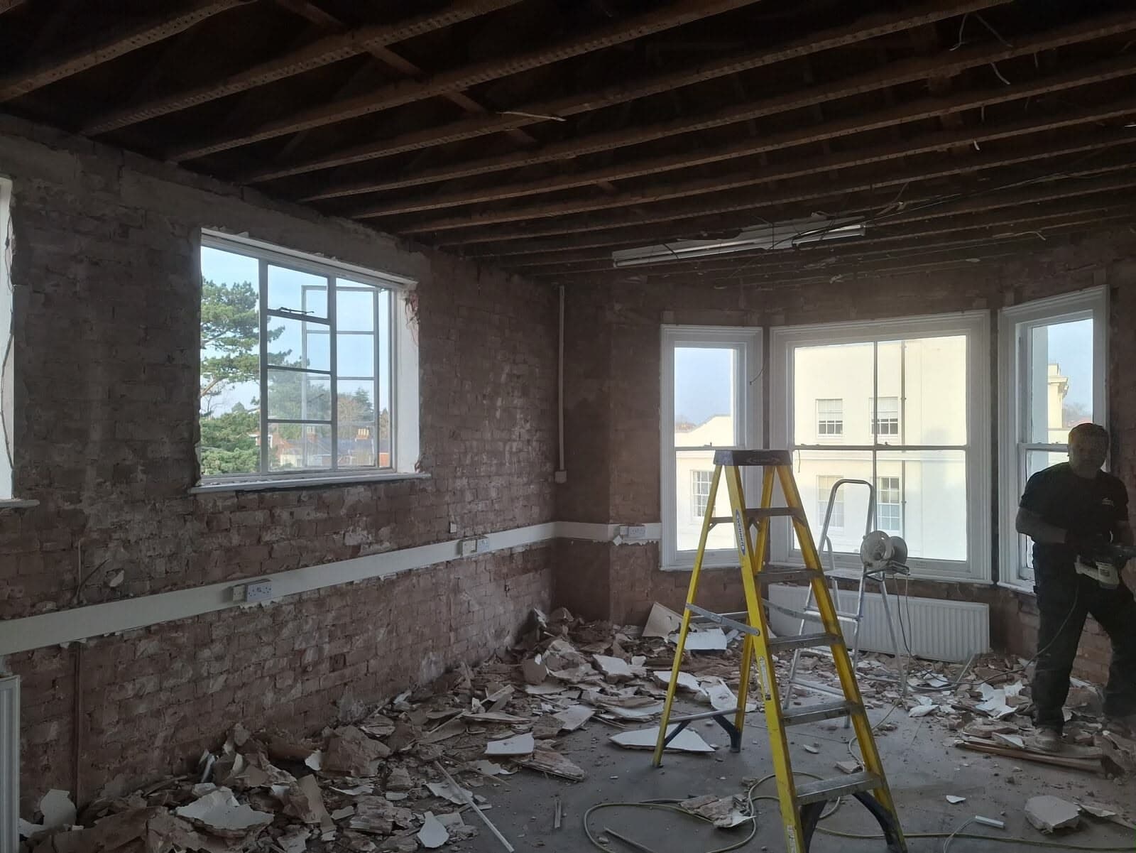 A bay-windowed room stripped back, with work in progress